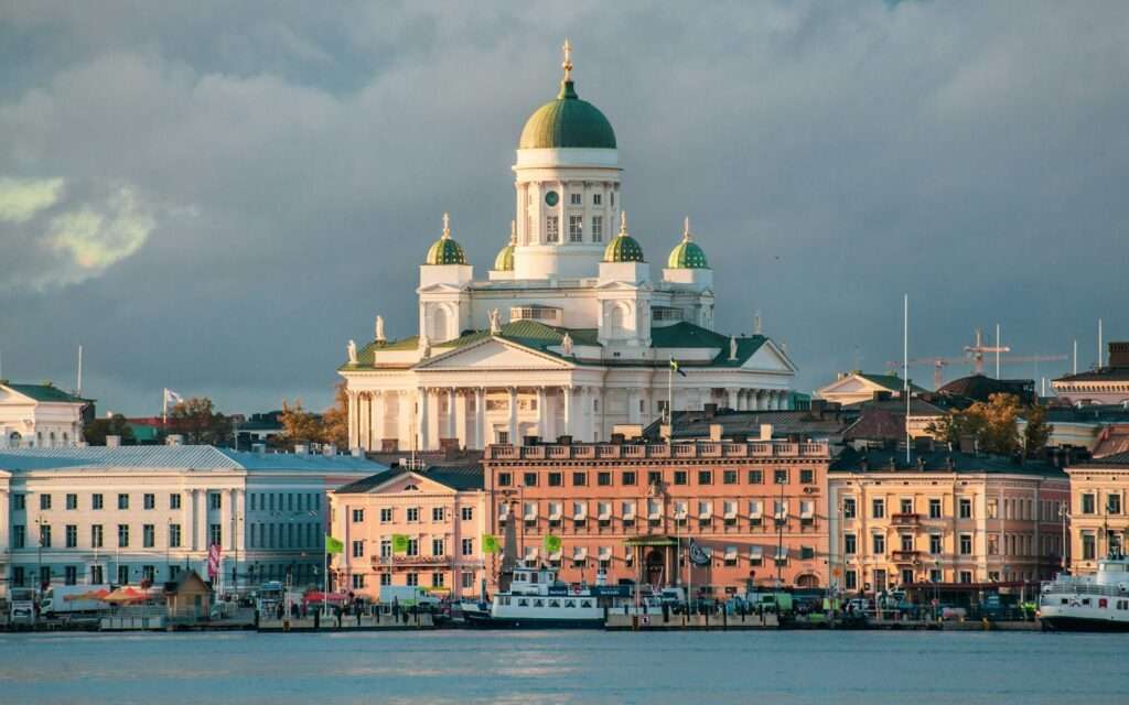 Helsinki Cathedral rising above Market Square and the harbor in low golden light